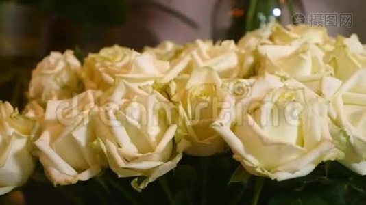 在花店里，用一束束绿色的茎叶组成的白色鲜玫瑰特写镜头出售视频