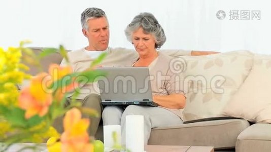 成熟的一对夫妇在他们的笔记本电脑上工作视频