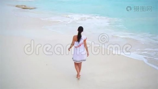 热带海滨的年轻美女。 年轻女孩穿着漂亮衣服的后景背景是大海视频
