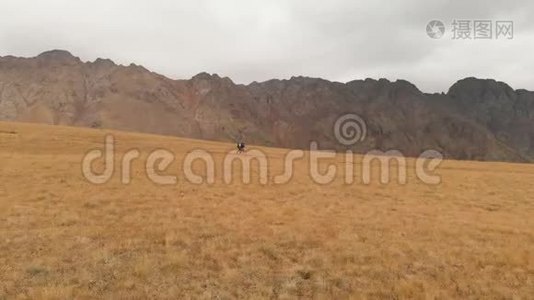 一对戴着帽子和太阳镜的大背包的旅行者男女在高山上漫步的鸟瞰图视频