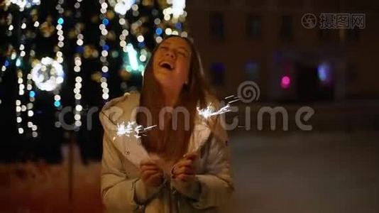 一个女孩拿着孟加拉灯对着圣诞树视频