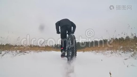 专业的极限运动员骑自行车在户外骑胖自行车。 后轮的近距离观察。 冬天骑自行车视频