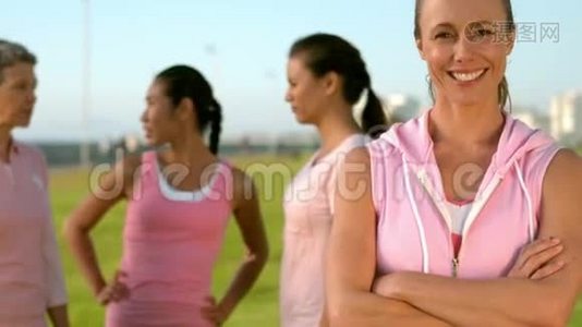 微笑的女人在朋友面前穿着粉红色的乳腺癌视频