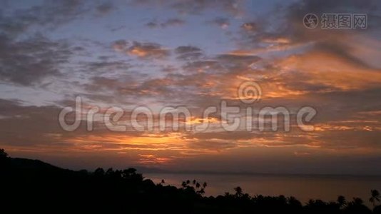 雄伟的热带橙色夏季，夕阳在海面上，群山的轮廓。 戏剧性黄昏的空中景色视频