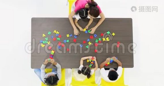 亚洲老师和学生玩字母玩具。视频