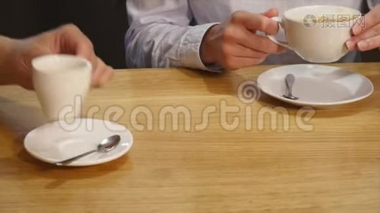 两个人在咖啡馆里喝着咖啡笑着视频