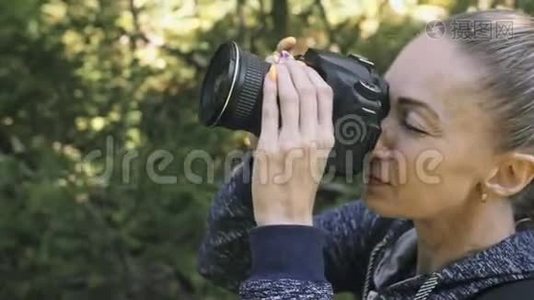 游客在森林中拍摄风景。 一个高加索女人近距离射击。 女孩在dslr上拍照视频