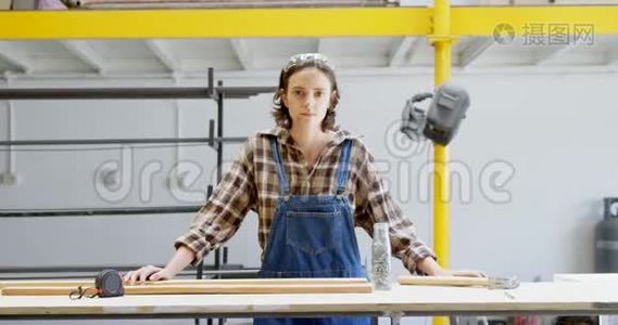 4k车间用木板站立的女焊工视频