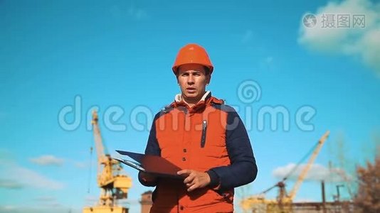 工程建设人咨询工地上的人手里拿着蓝图。 建筑检查员。 高级视频