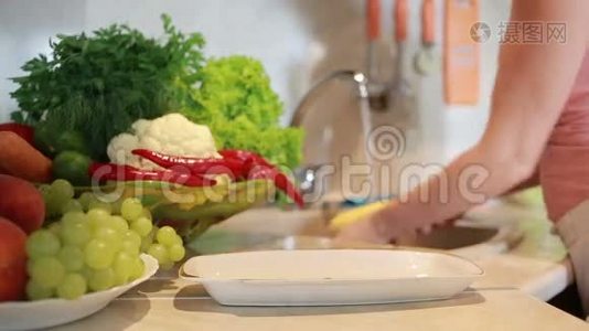 女孩洗玉米。 厨房桌子上的蔬菜视频