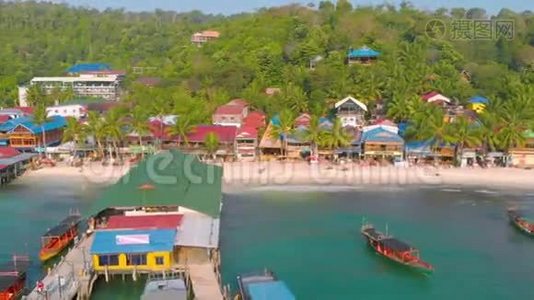 柬埔寨KohTouch村海岸的空中景观被棕榈树包围，在KohRong有码头和长尾船。视频