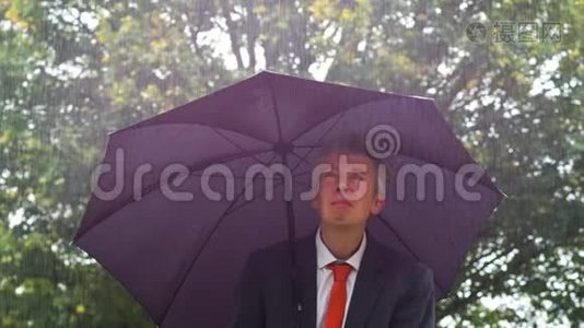 白人商人躲在雨中的伞下视频