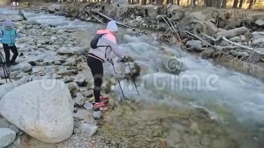 女人在大自然中行走，靠近山河。 女孩和孩子使用跋涉棒和北欧杆视频