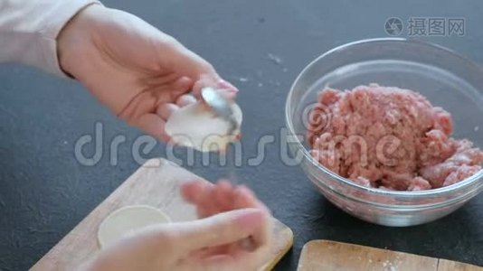 女人用肉馅包饺子，特写的手。视频