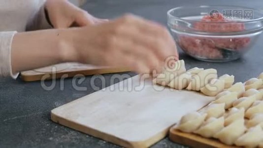 女人用肉馅包饺子，特写的手。视频