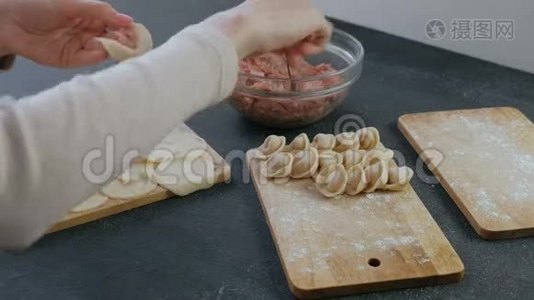 女人用肉馅包饺子，特写的手。视频