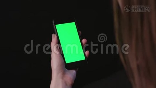 女人拿着手机，绿色屏幕轻敲视频