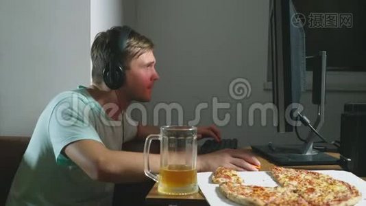 技术、游戏、娱乐、游戏和人的概念。 一个年轻人在家玩电脑游戏，喝啤酒视频