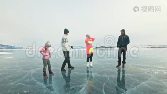 家庭在大自然中冰上做运动。 父亲在冬天训练他的家人。 母女和儿子看着他视频