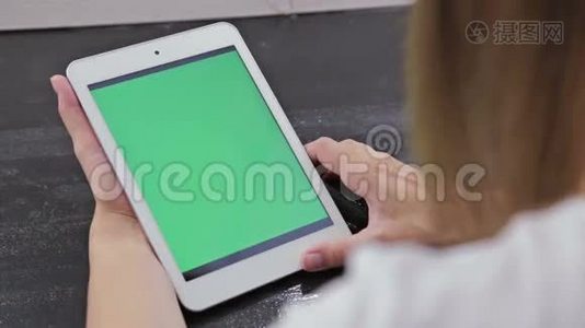 女人看着绿色屏幕的立式平板电脑视频
