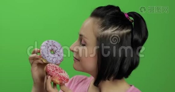 快乐美丽的女孩摆姿势，玩甜甜圈。 铬键视频