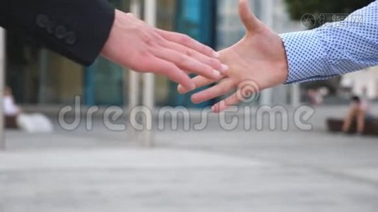 同事在城市背景下见面握手.. 两个商人在城市环境中互相问候视频
