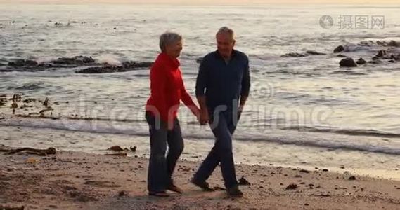 年长夫妇在海滩上散步4K视频