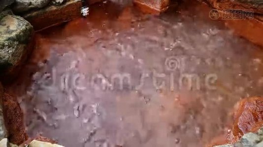 Kabardino-Balkaria山上有红墙的井中的沸腾矿泉水泡沫的来源视频