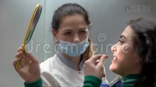 带着病人拿着镜子的牙医。视频