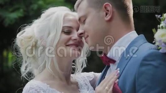 新婚快乐在公园拥抱亲吻。视频