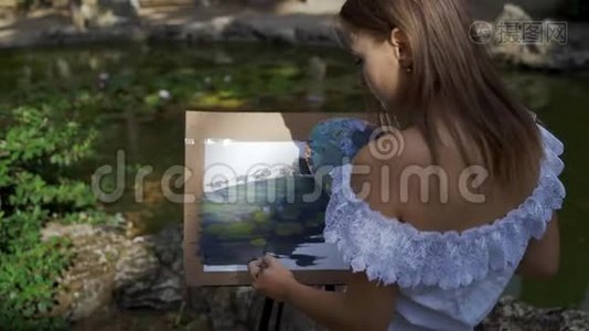 公园里的女画家用油画画了一个小池塘视频