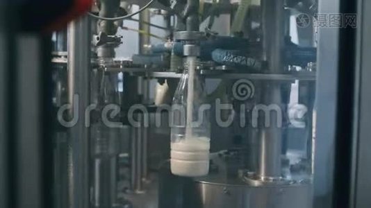 在一家牛奶厂，用于将乳制品倒入塑料瓶的输送线，在慢速中以全HD分辨率进行。 A.视频