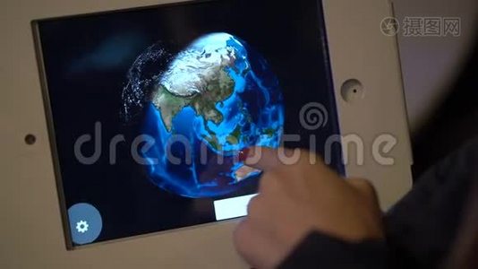 一个人触摸平板电脑并绕着地球模型运行的慢动作镜头。 天文博览会视频