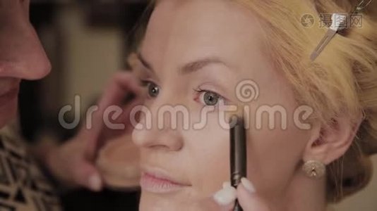 专业化妆师将模特化妆照片应用于女性。视频