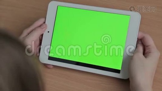 女人在平板电脑上看视频，绿色屏幕视频