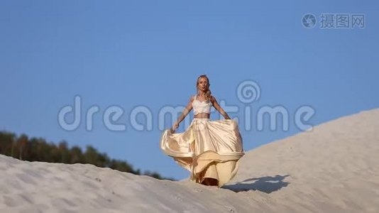 美丽的新娘穿着时尚的飞行服装和花环在迪拜的大沙漠。视频