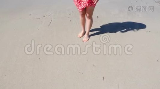 年轻的女人穿着红色的裙子在沙滩上画着一颗心。 海滩的心脏图视频
