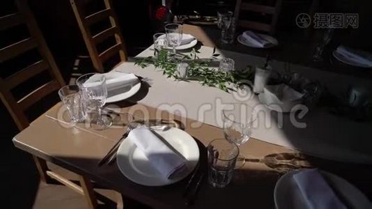 眼镜，盘子，餐具和餐巾.. 为聚会装饰了鲜花的桌子。 婚宴，生日视频