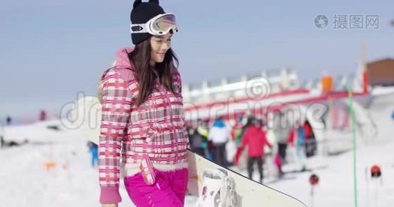 年轻女子拿着滑雪板走路视频