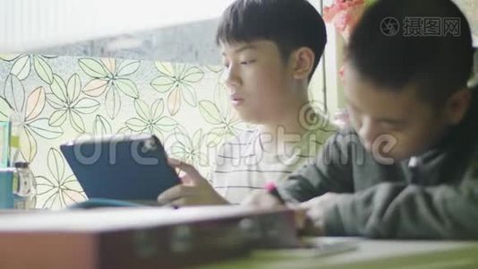 快乐的小男孩在做你的家庭作业。视频