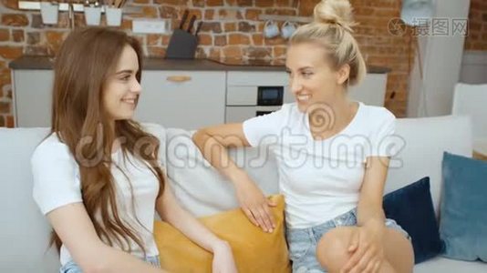 两个快乐的少女女友在家放松的肖像。视频