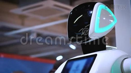 新型现代白色机器人的肖像.. 机器人转过头，看着摄像机。 机器人及高科技展览视频