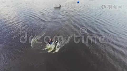 穿着潜水衣的帅哥正在河上骑着一辆尾板视频