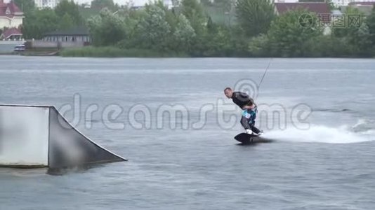 穿着潜水衣的帅哥正在河上骑着一辆尾板视频