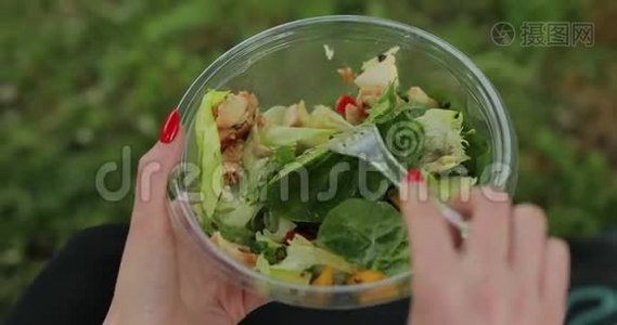 坐在草地上吃沙拉的女人视频