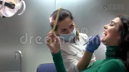 牙医和病人拿着镜子。视频
