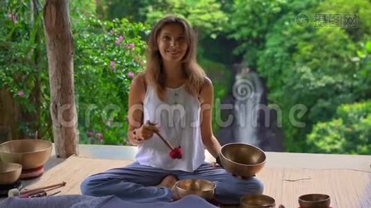 一位亚洲圣药大师为一位年轻的客户表演藏碗治疗仪式的女子拍摄的超慢镜头视频
