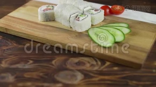 桌子上摆着寿司卷。 餐厅提供各种日本菜。 配有鲑鱼、金枪鱼和蔬菜视频