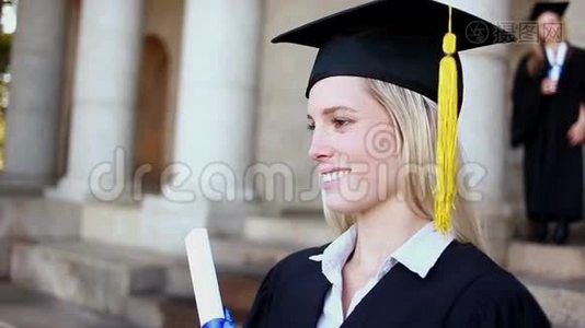 微笑的金发学生拿着她的文凭视频