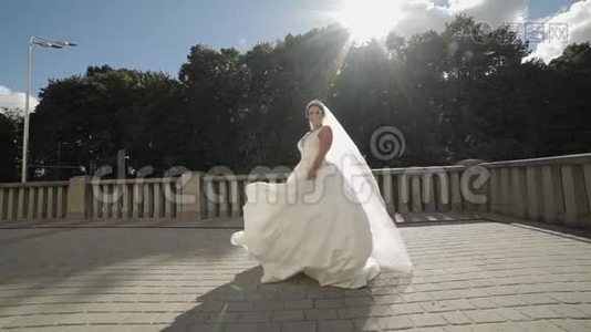 美丽可爱的新娘穿着婚纱，戴着面纱。 慢动作视频